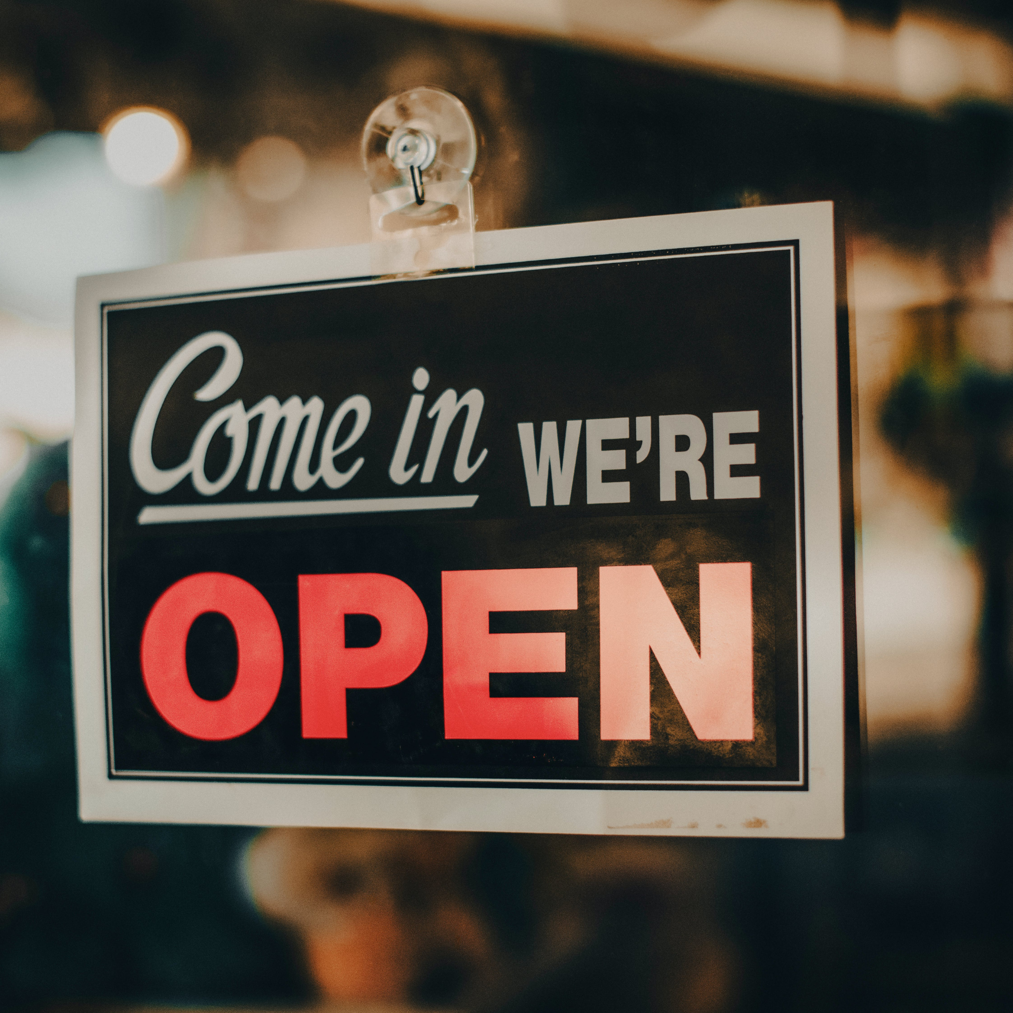 a sign hanging on the door stating the business is open
