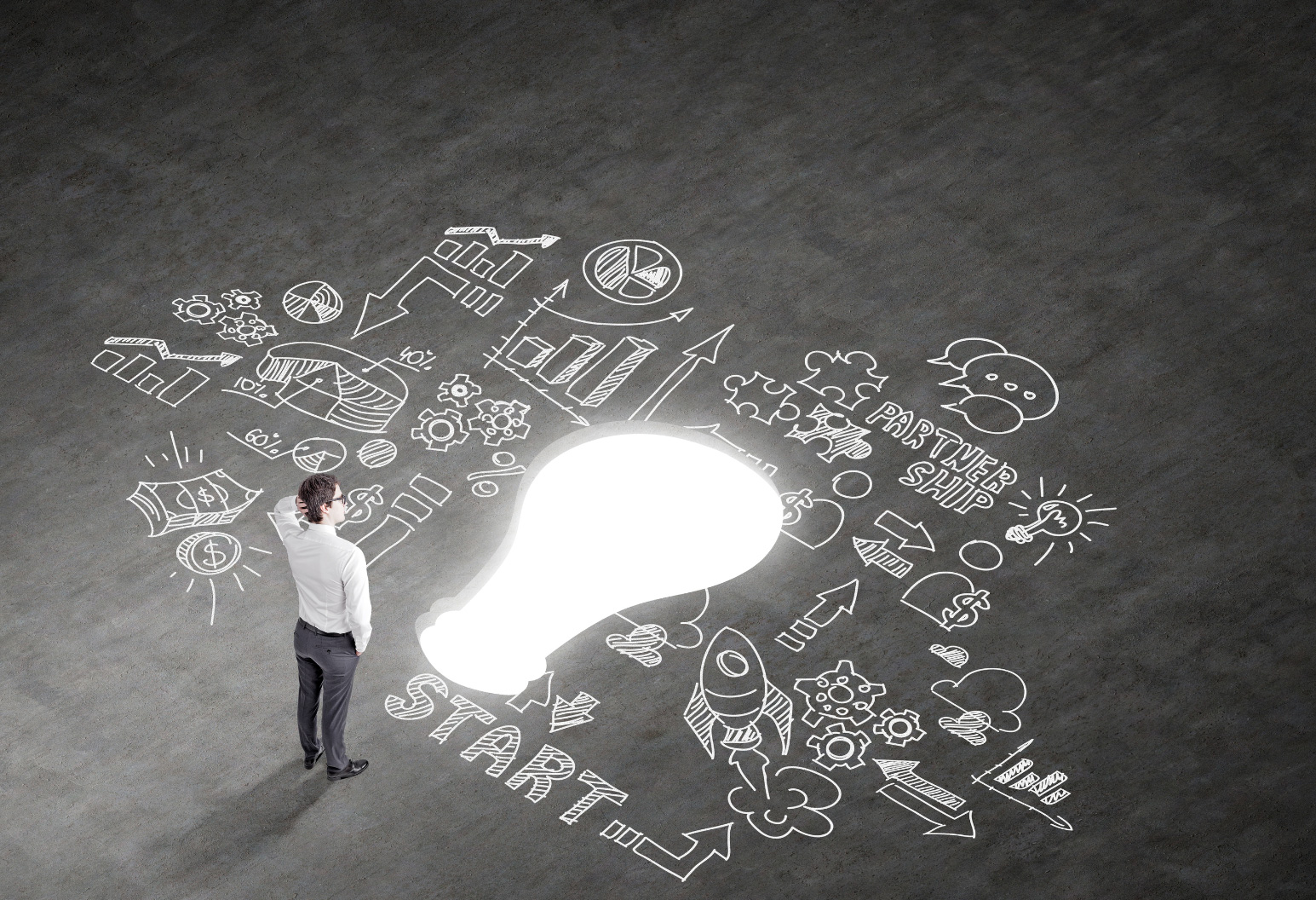 Business ideas written down in chalk with a light bulb in the center